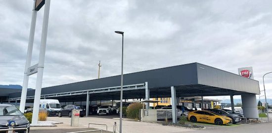 Avtosalon Toyota in Fiat z avtomobili na pokritem parkirišču.