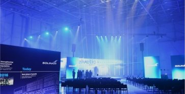 Event at the hangar opening at Brnik Airport with stage and aircraft in the background.