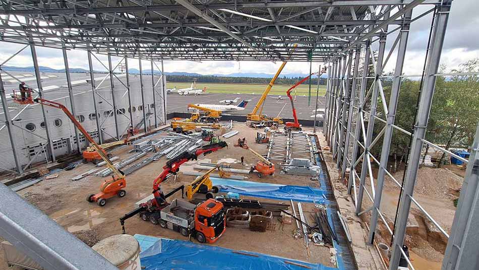 Montage der letzten Dachträger der Stahlkonstruktion des Solinair-Hangars.
